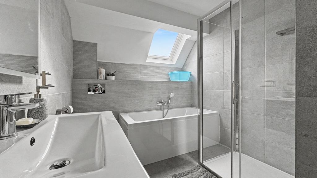 Modern, well-lit bathroom with a full bath, sep...