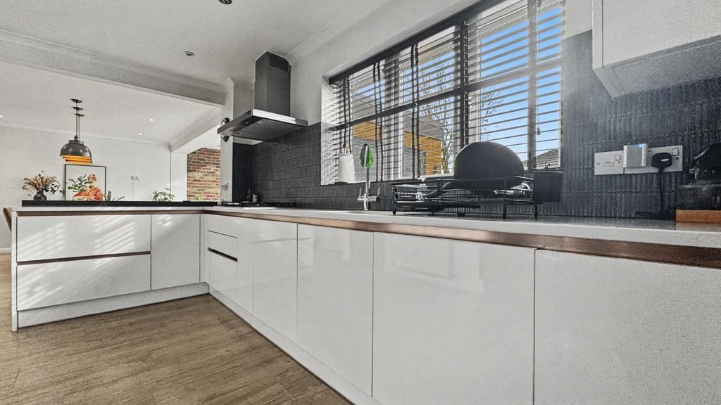 Bright, modern kitchen with glossy white cabine...