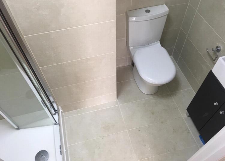 Modern tiled bathroom with a corner shower encl...