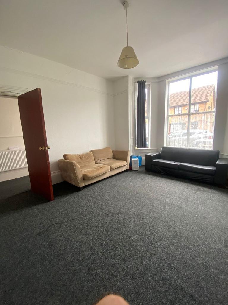 Bright, spacious living room with large front w...