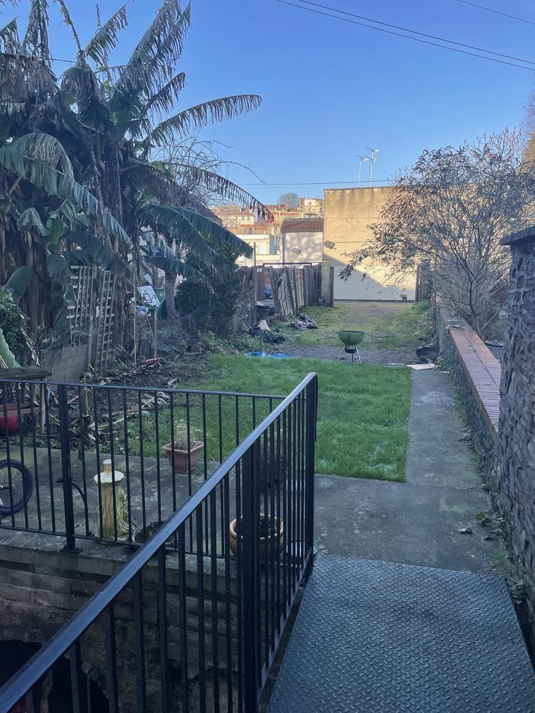 Long rear garden with a paved terrace, central ...