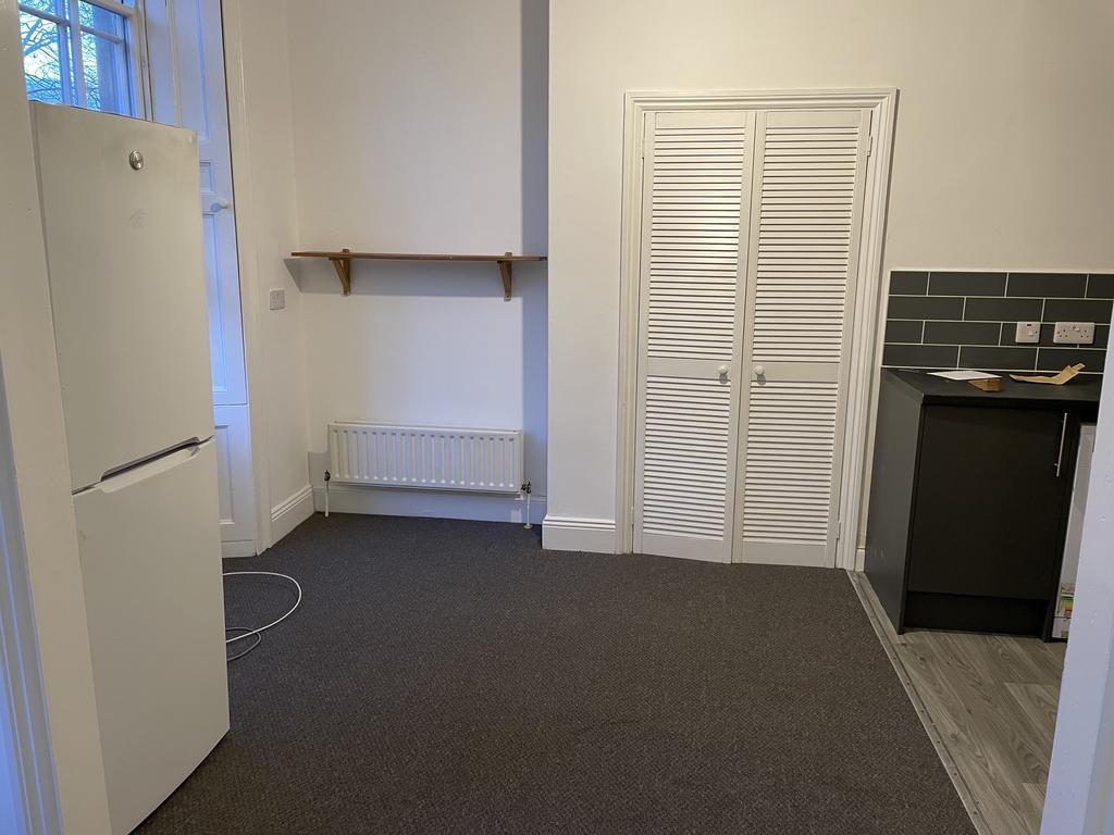 Neat kitchen area with a freestanding fridge, h...