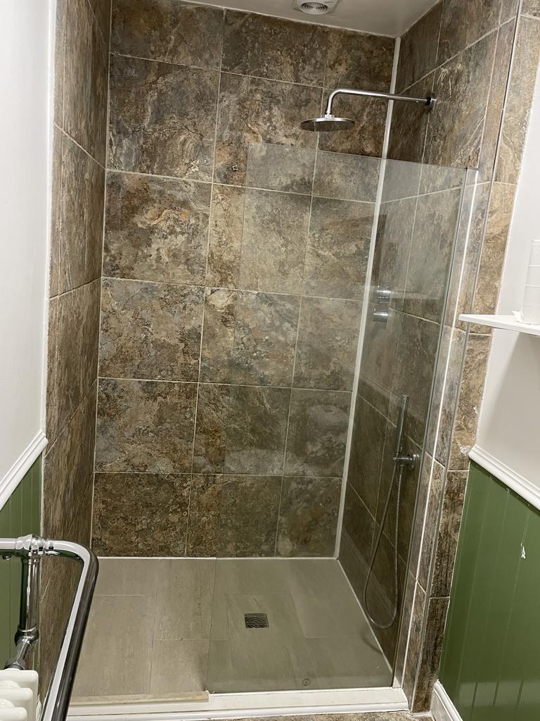 Contemporary tiled walk-in shower with rainfall...