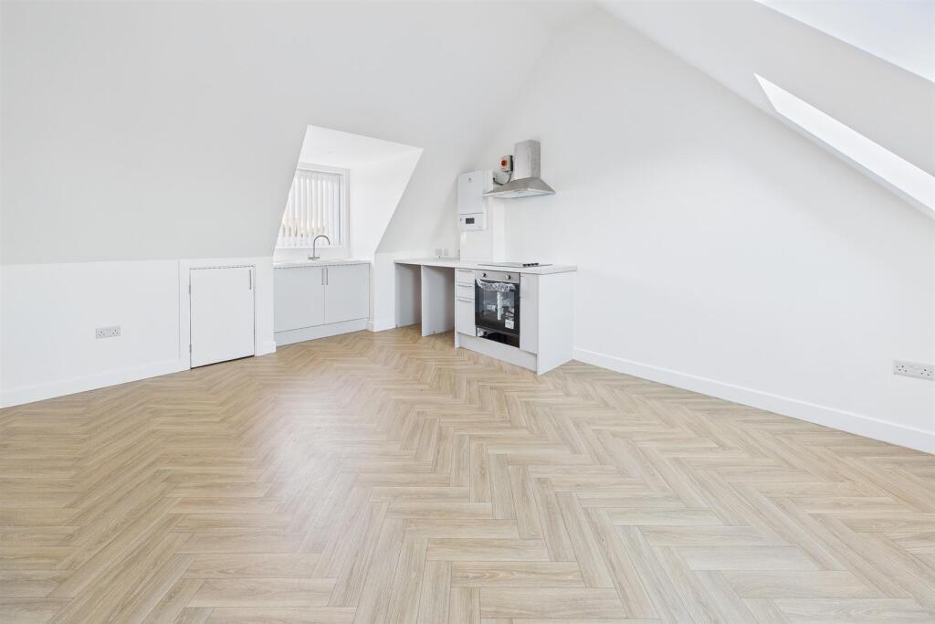 Bright, airy top-floor living space with sloped...
