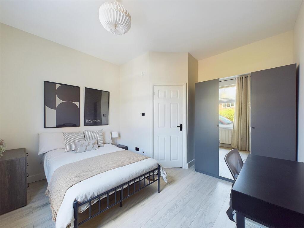 Bright, neatly styled double bedroom with a cle...