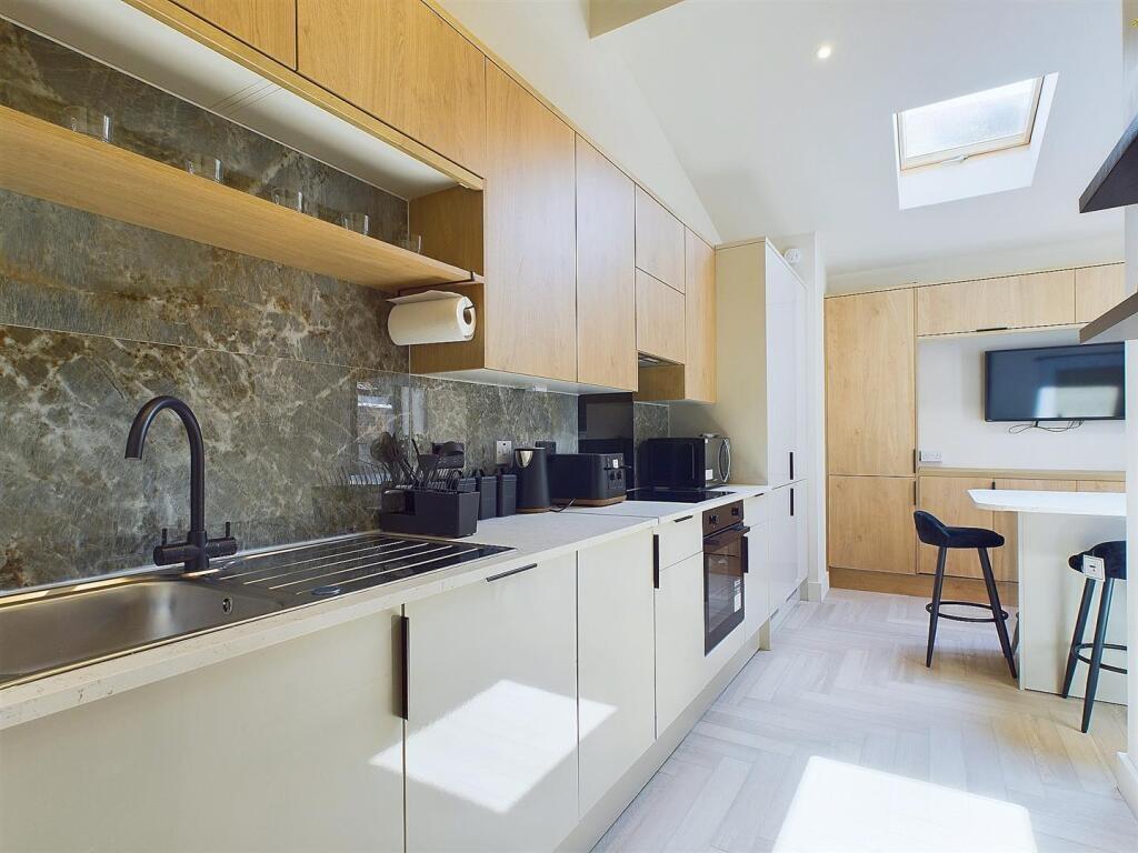 Modern fitted kitchen with sleek cabinetry, int...