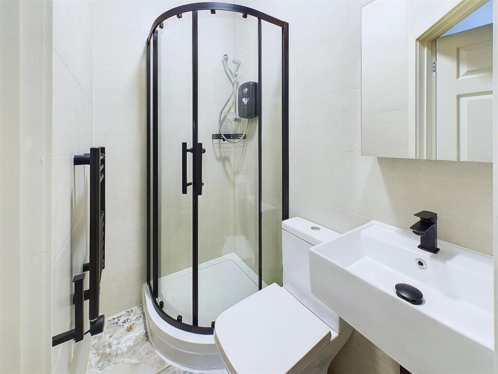 Bright, modern bathroom with a curved glass sho...