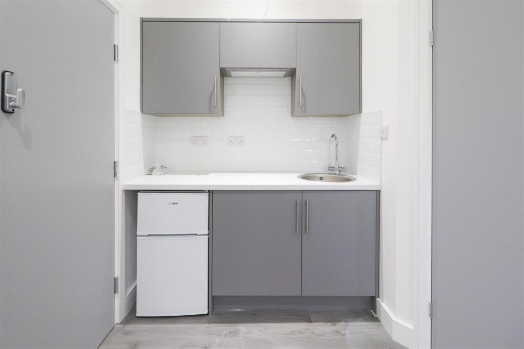 Modern compact kitchenette with grey cabinets, ...