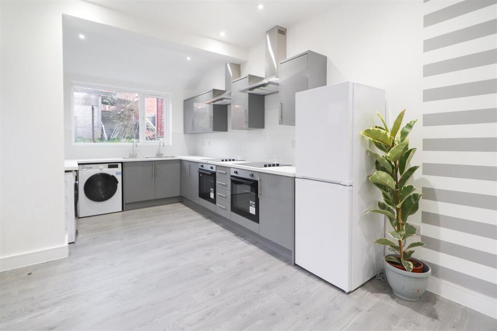 Bright, modern galley kitchen with sleek grey c...