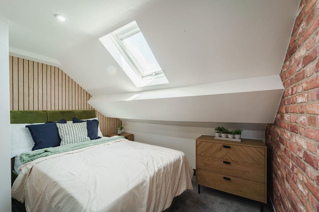Cozy double bedroom in a loft-style space featu...