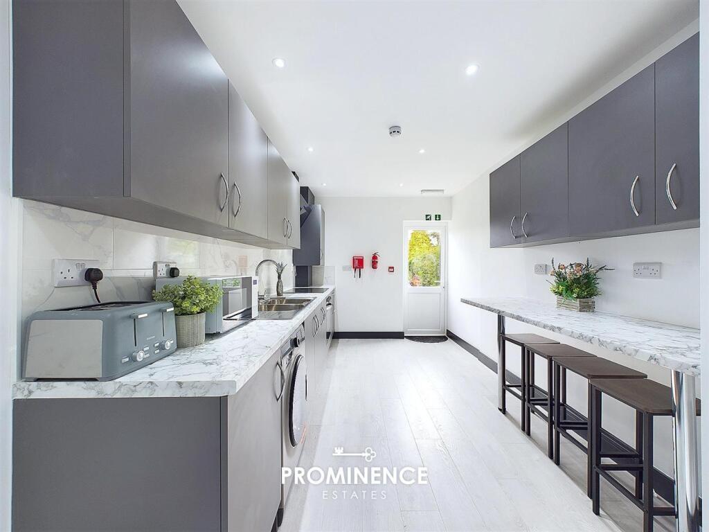 Bright, modern galley kitchen with sleek grey c...