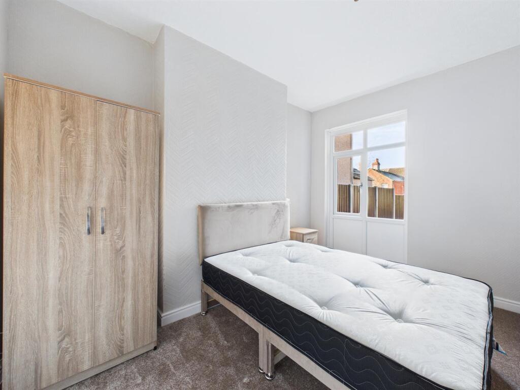 Bright, neutrally decorated single bedroom with...
