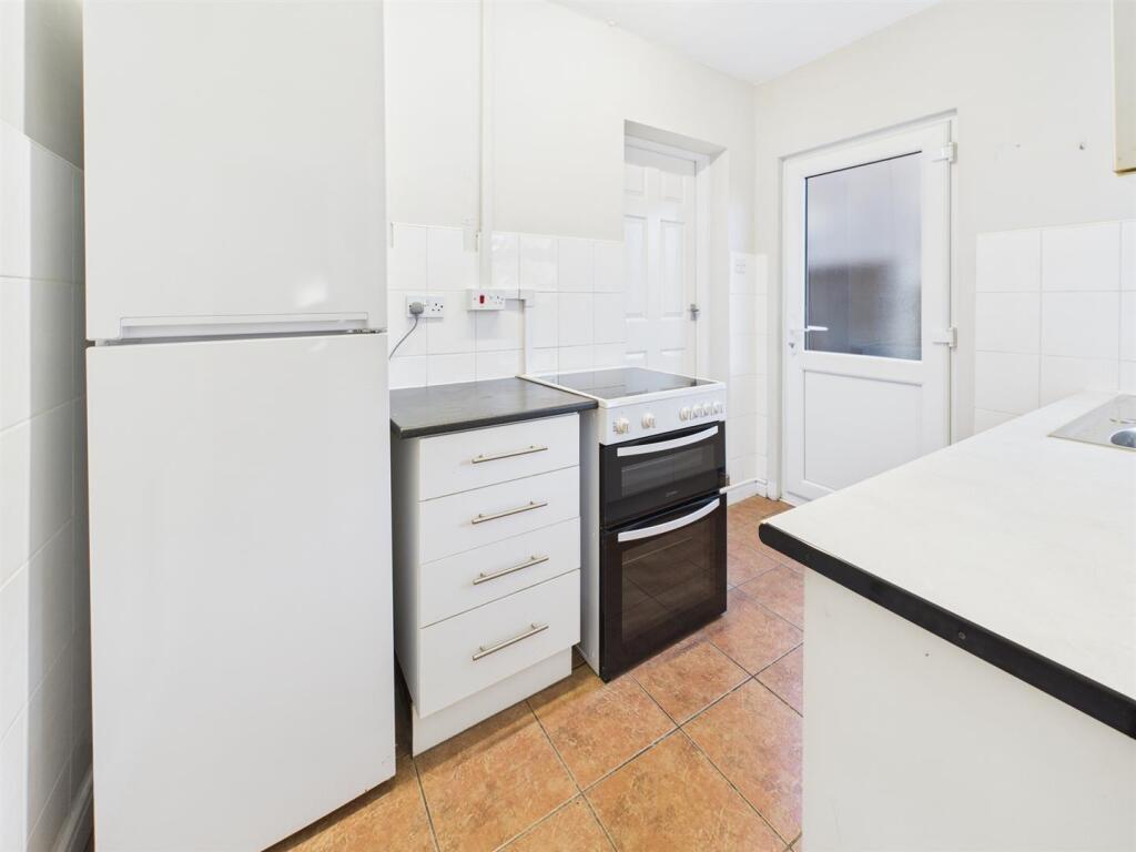 Bright, modern kitchen with white units, a free...