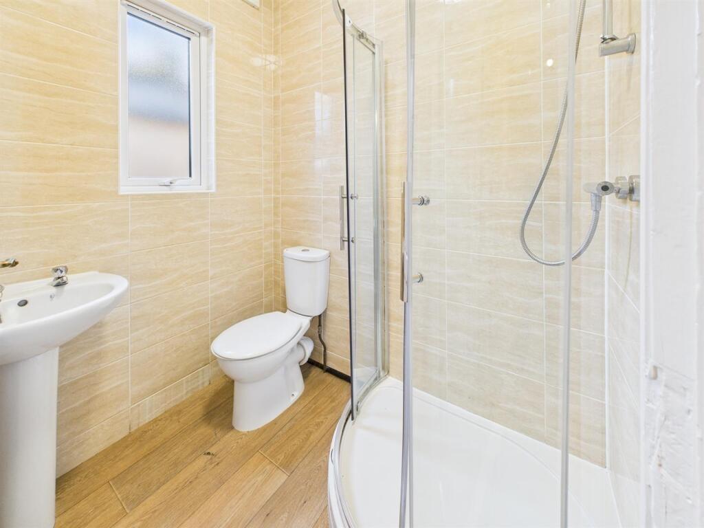 Bright, modern bathroom featuring a walk-in gla...