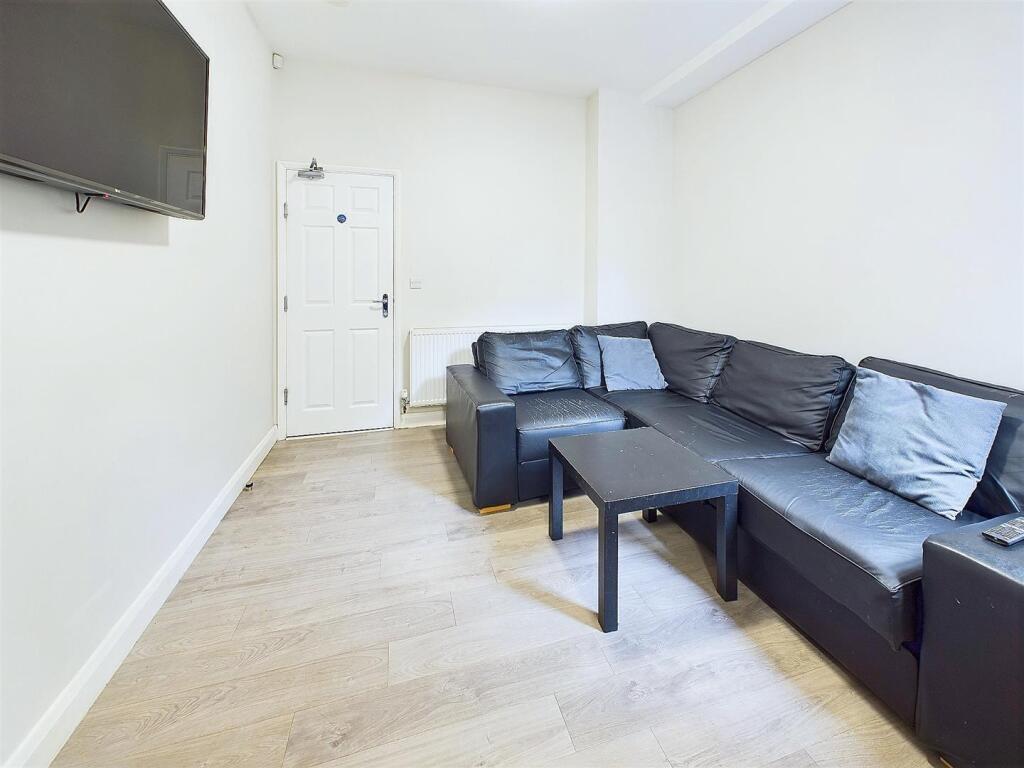 Bright, simple living room with a black L-shape...