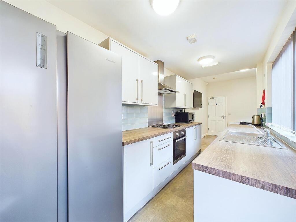 Bright, modern galley kitchen with stainless-st...