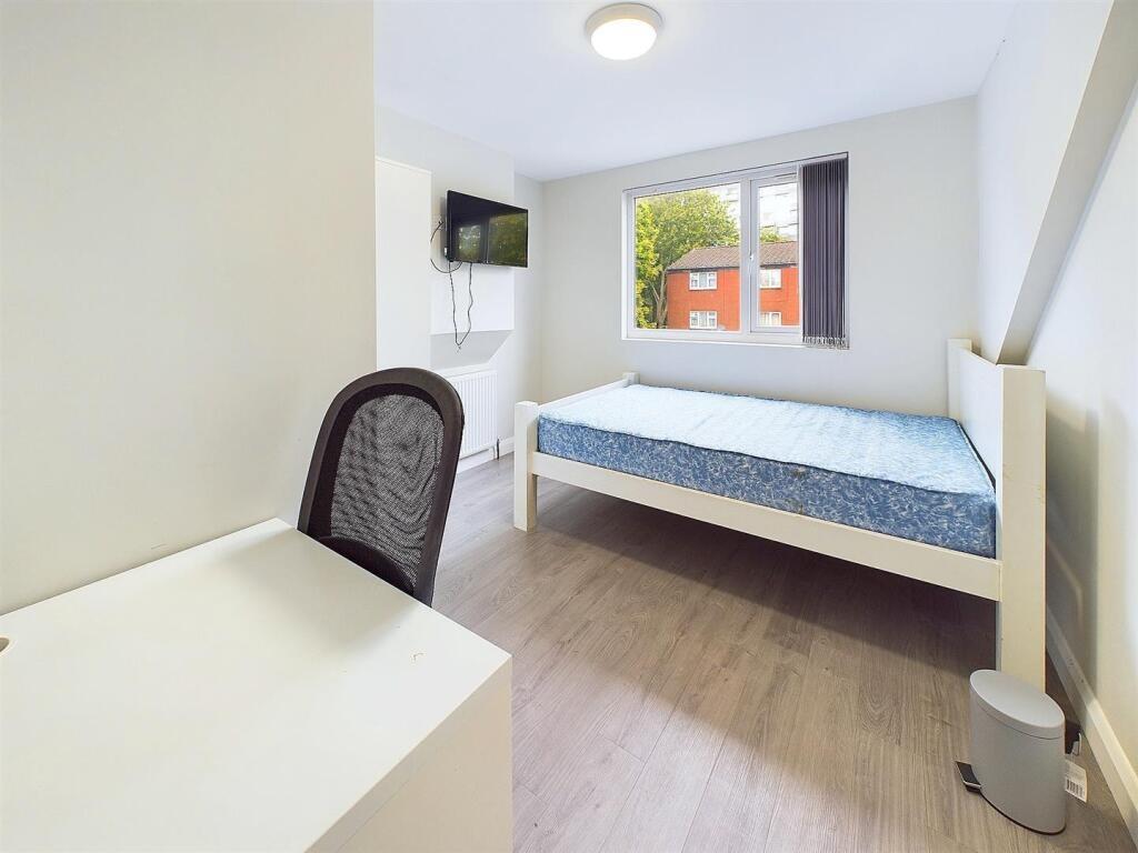 Bright, simply furnished bedroom with a single ...