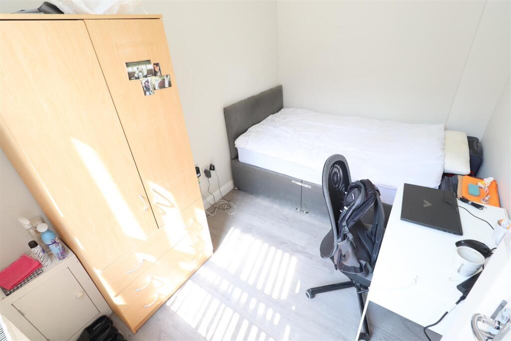Bright, simply furnished bedroom with a single ...
