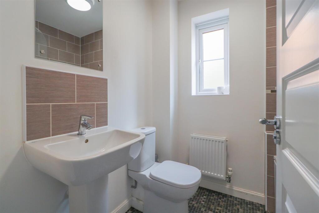 Bright, modern bathroom with a pedestal sink, c...