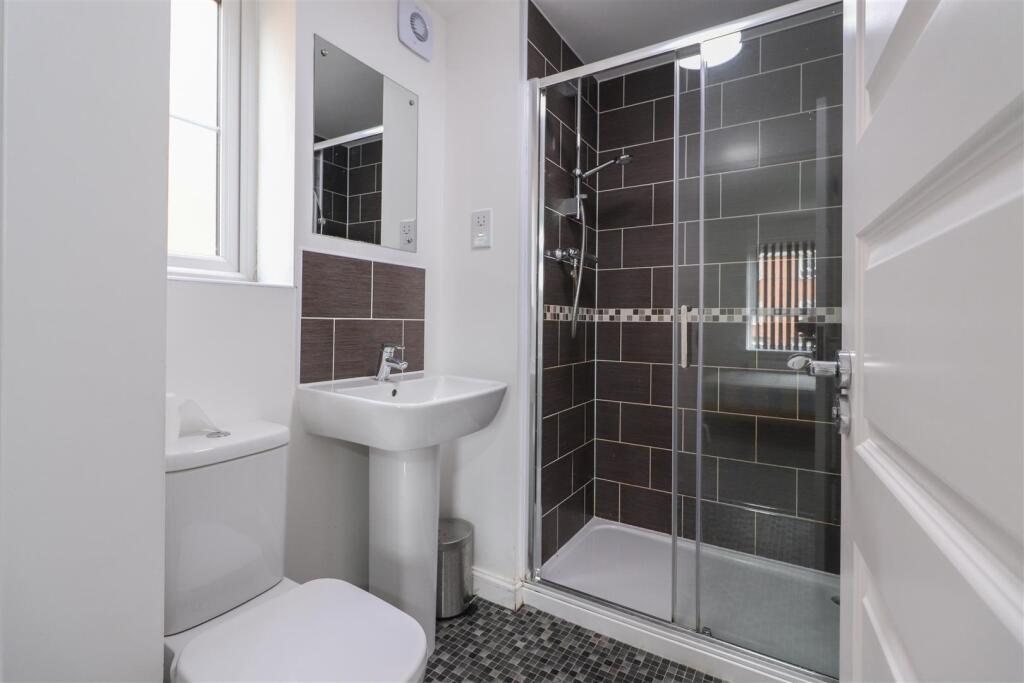 Modern bathroom with a glass-enclosed shower, p...
