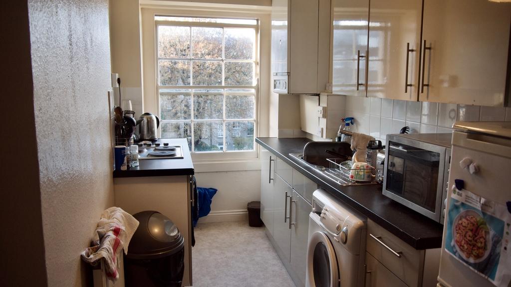A bright and tidy kitchen with ample natural li...
