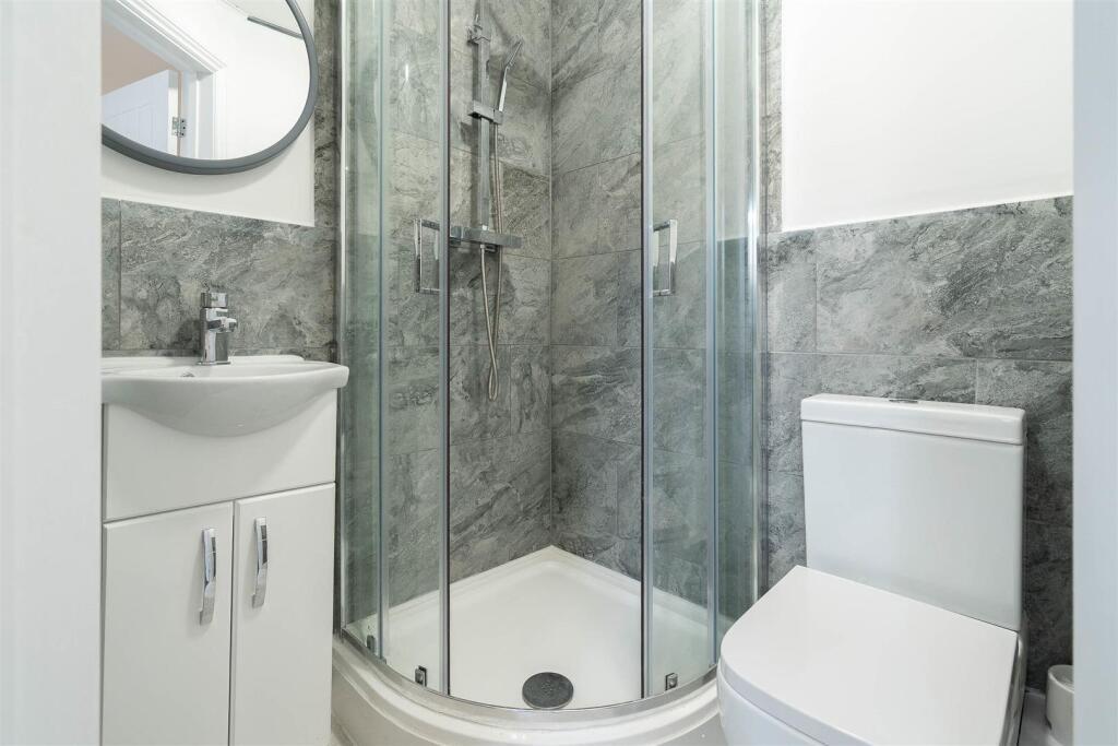Modern ensuite bathroom with a corner glass sho...