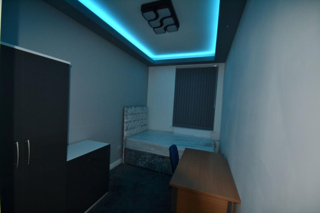 Compact, modern bedroom with a single bed, desk...