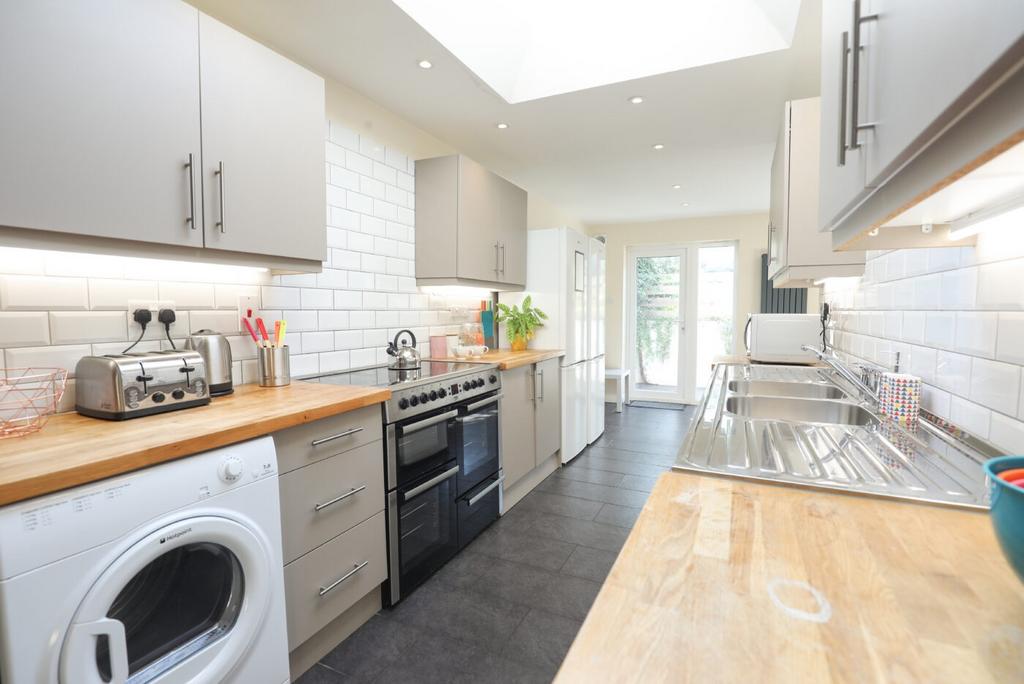 Bright and modern kitchen featuring white subwa...