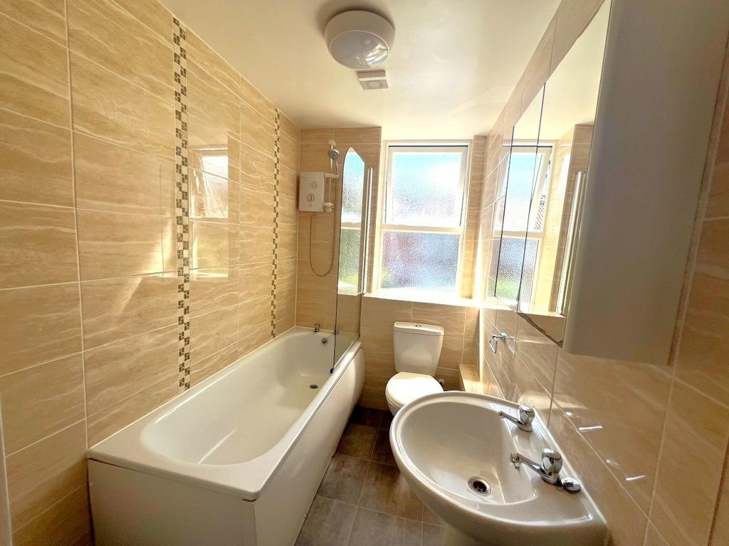 Bright and clean bathroom featuring a white bat...