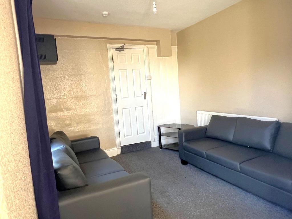 Bright, simply furnished living room with two m...