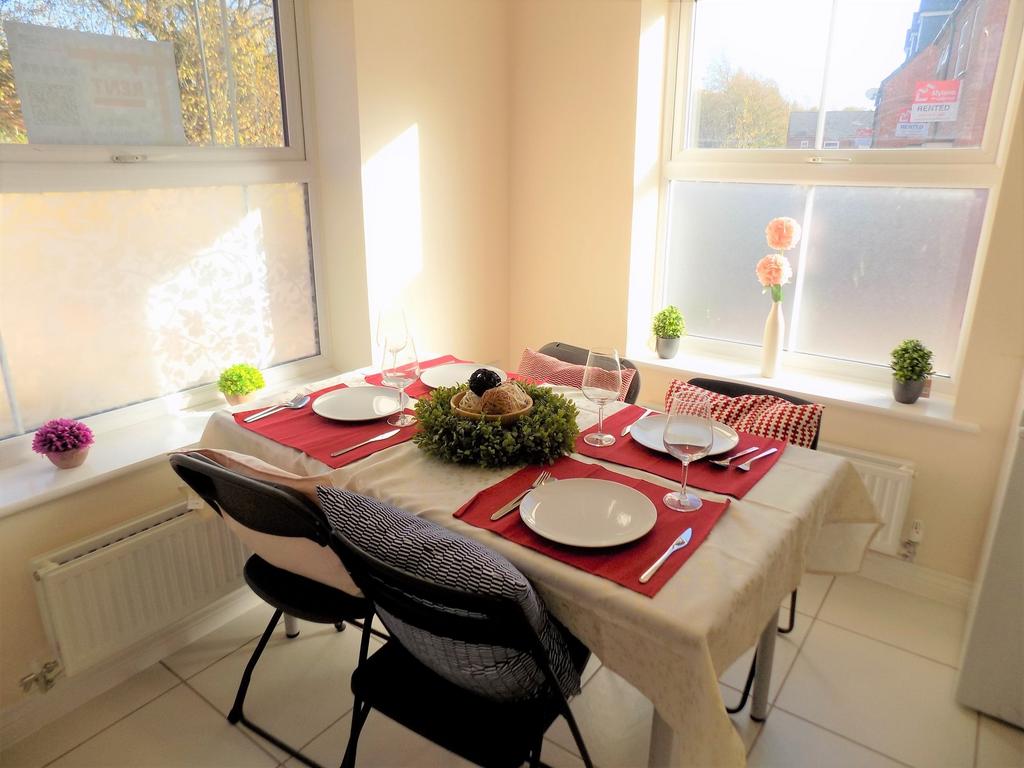 Bright, sunlit dining nook with a neatly set ta...