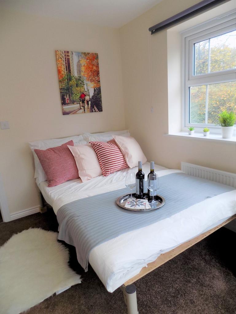 Bright, neatly made bedroom with a comfortable ...