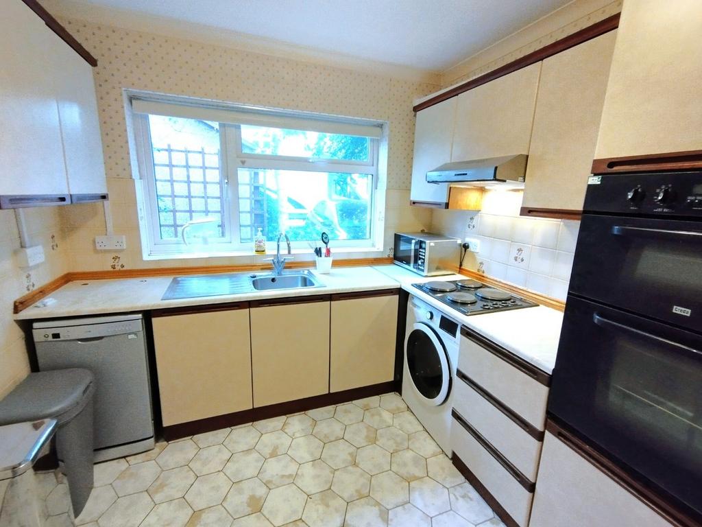 Bright galley-style kitchen with a large window...