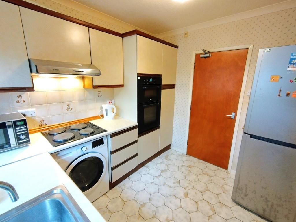 Compact fitted kitchen with integrated applianc...