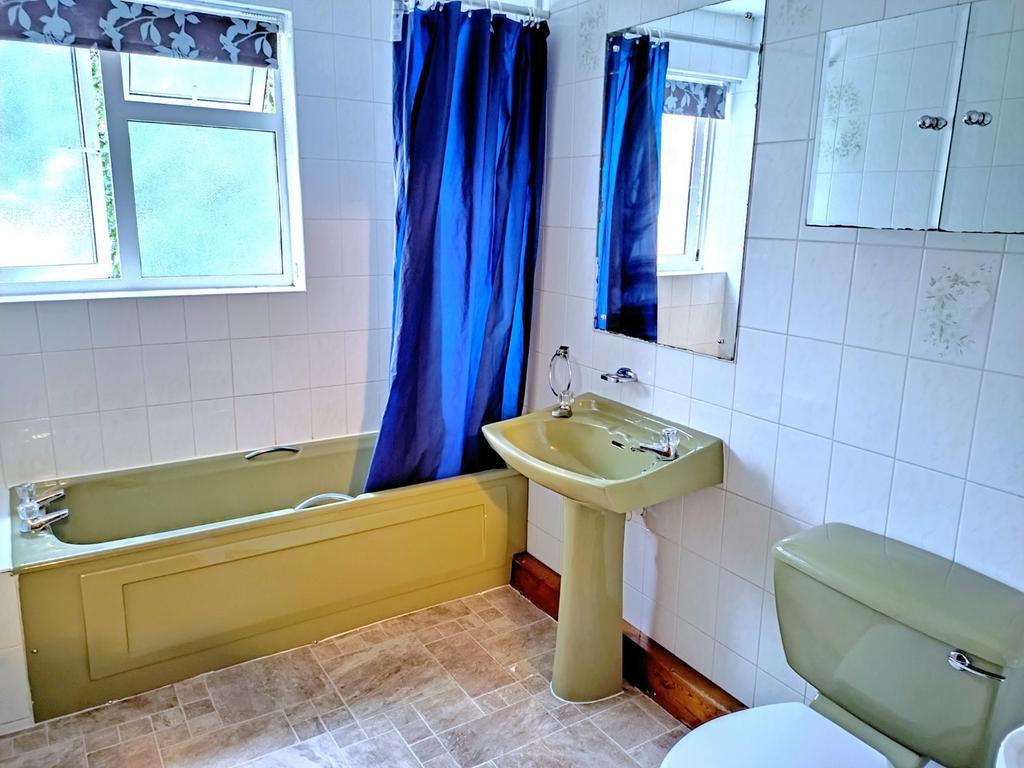 Bright tiled bathroom with a bathtub, pedestal ...