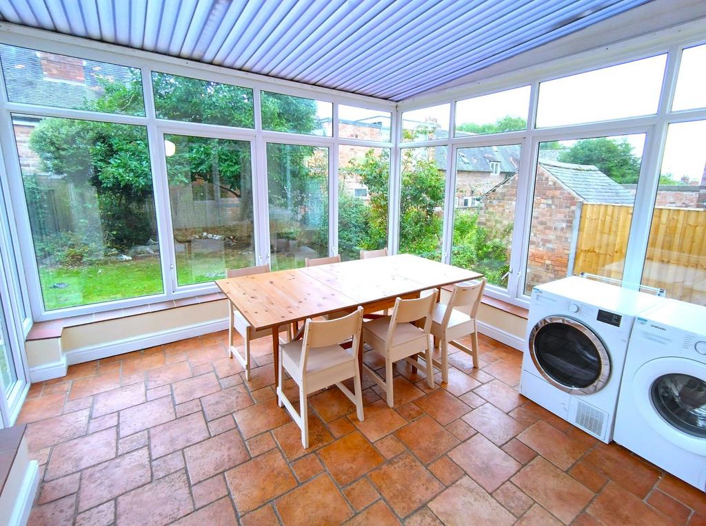 Bright, glass-fronted conservatory with terraco...