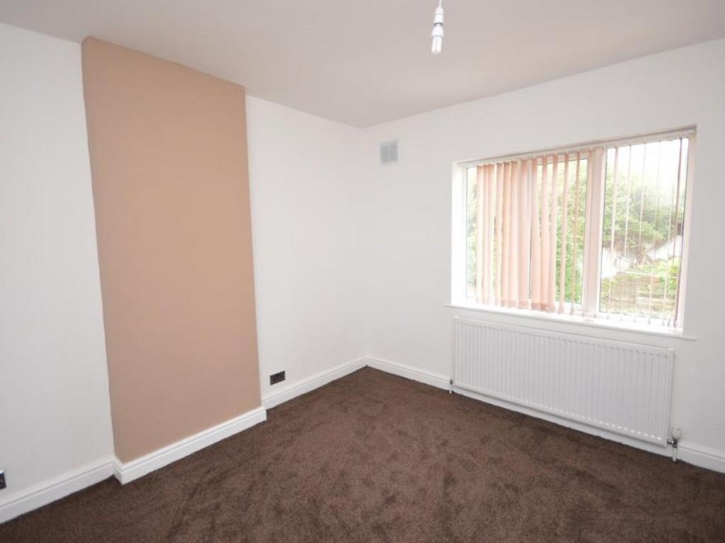 A bright and tidy bedroom with neutral walls an...