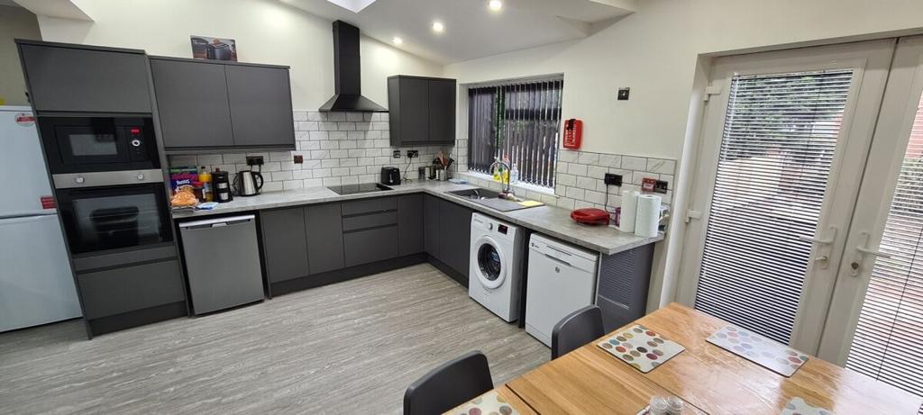 Modern kitchen with sleek dark cabinetry, large...