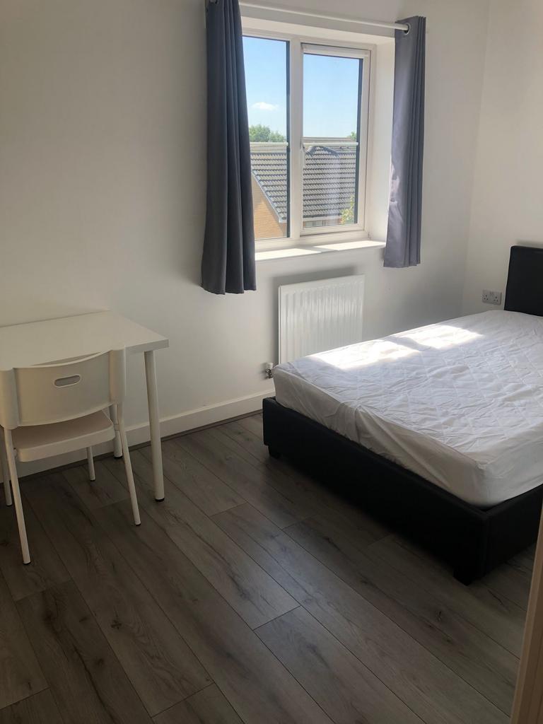 Bright, simply furnished bedroom with a comfort...