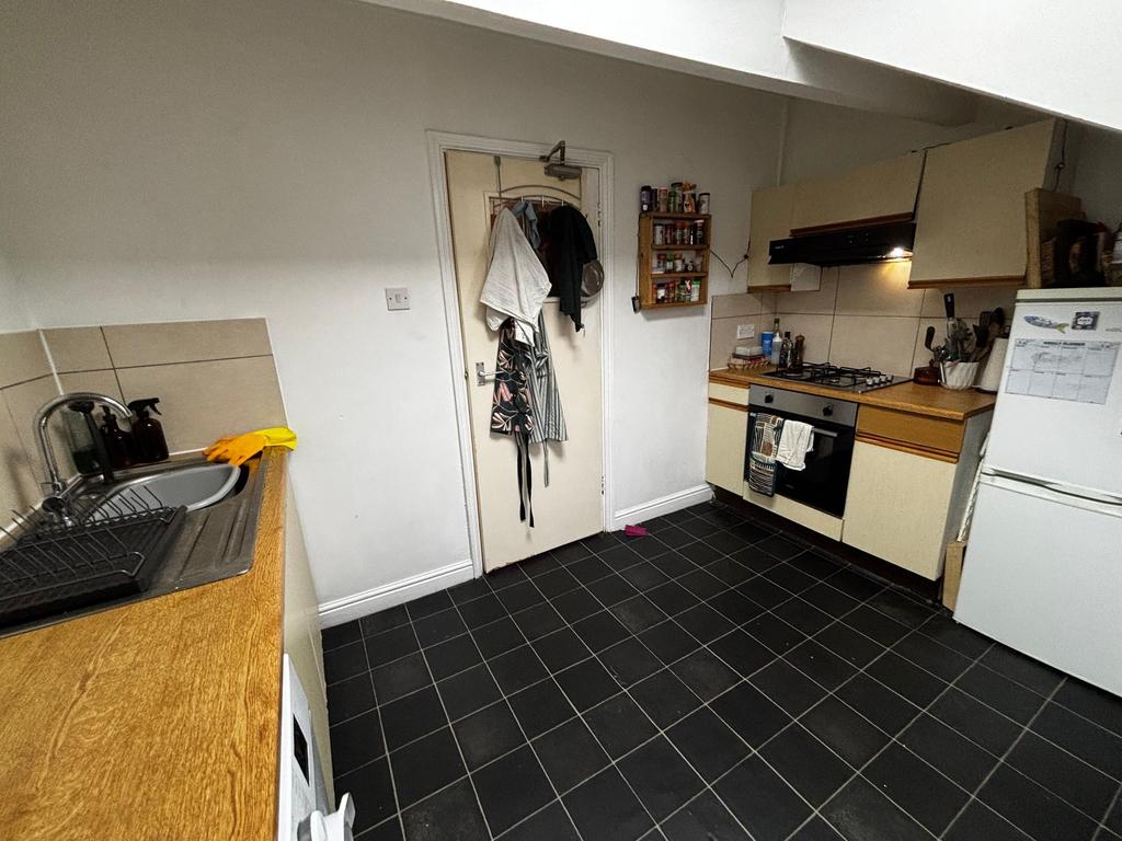 Compact fitted kitchen with tiled flooring, woo...