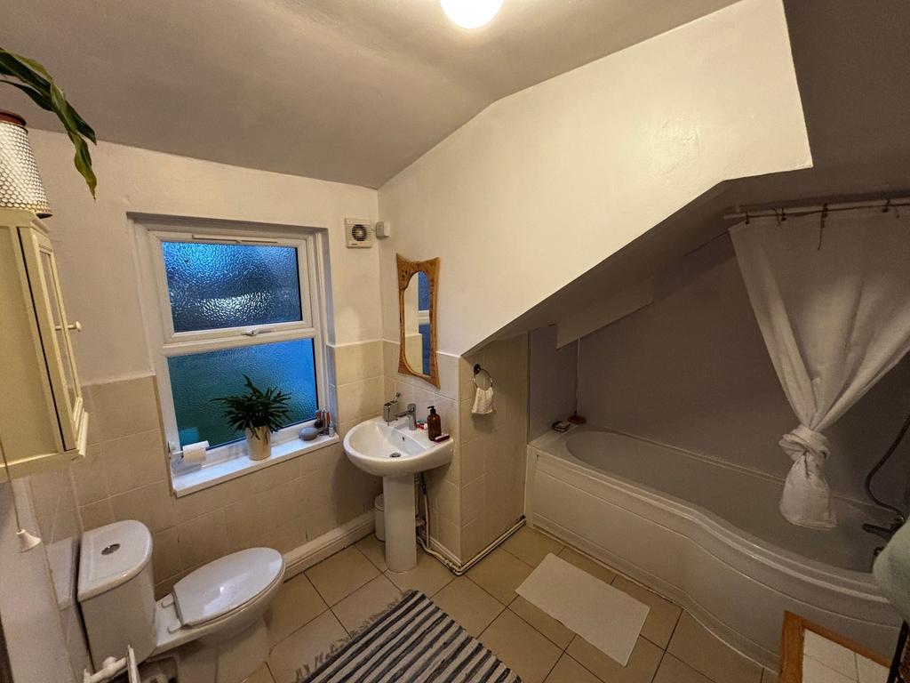 Bright, well-kept bathroom with a shower-over-b...