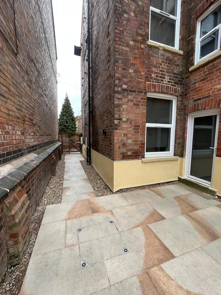 Neat paved side courtyard between brick buildin...