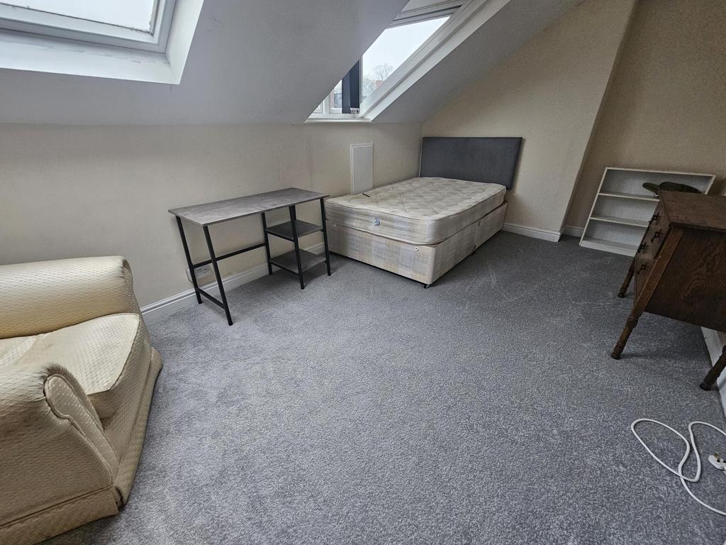 Bright attic bedroom with a double bed, skyligh...