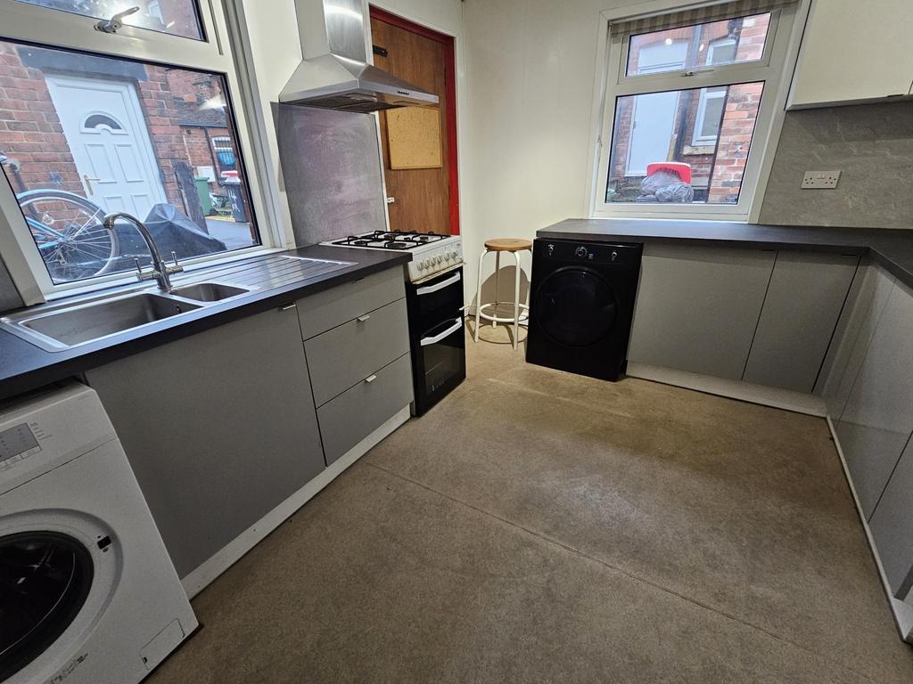Bright U-shaped kitchen with modern grey cabine...