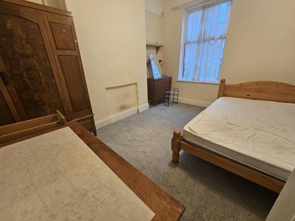 Bright, simply furnished bedroom with two woode...
