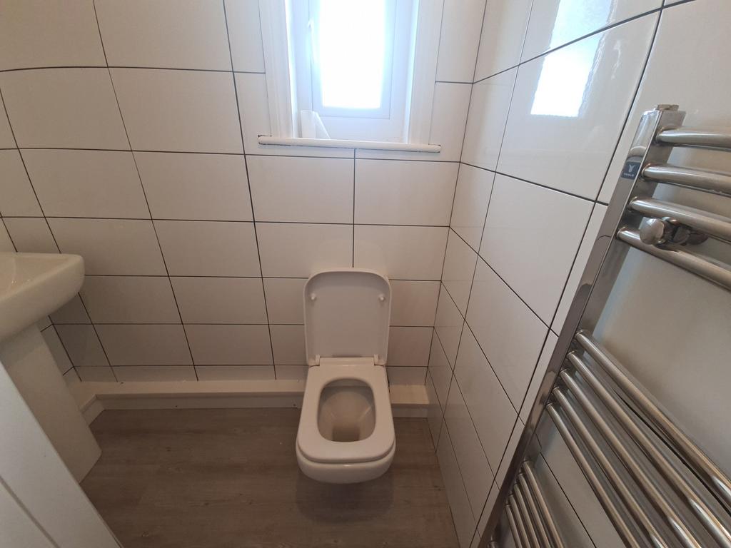 Neat tiled bathroom with a modern toilet, chrom...