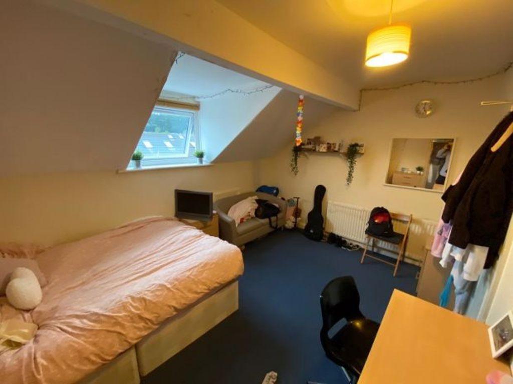 Cozy attic-style bedroom with a single bed, bui...