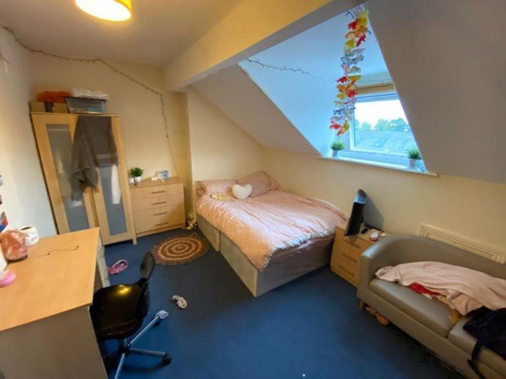 Bright, cozy attic bedroom with a comfortable s...