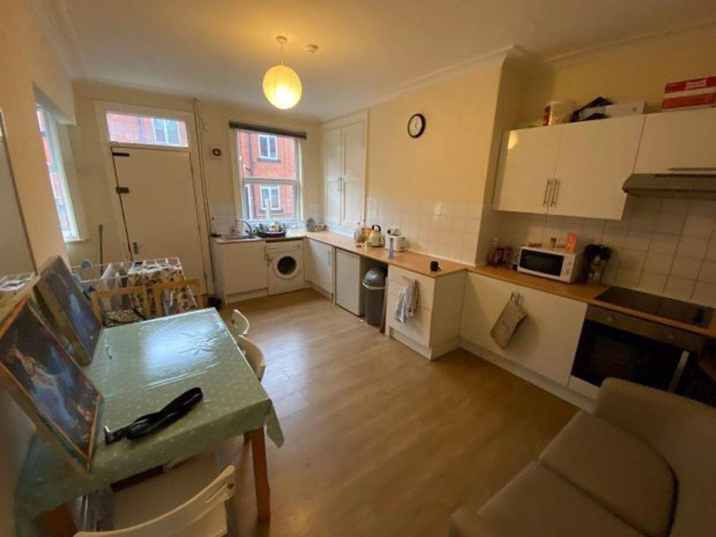 Bright, modern kitchen with light wood flooring...
