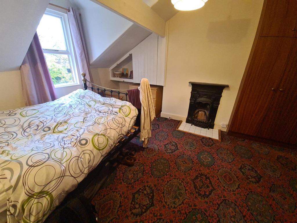 Cosy bedroom with a double bed, patterned carpe...